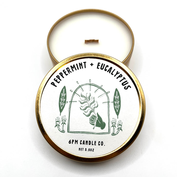 A travel-sized soy wax candle with a wooden wick, labelled '6pm Candle Co.', 'Peppermint + Eucalyptus'