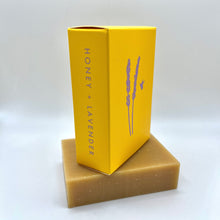 Load image into Gallery viewer, Bar soap with yellow packaging called 'Honey + Lavender'
