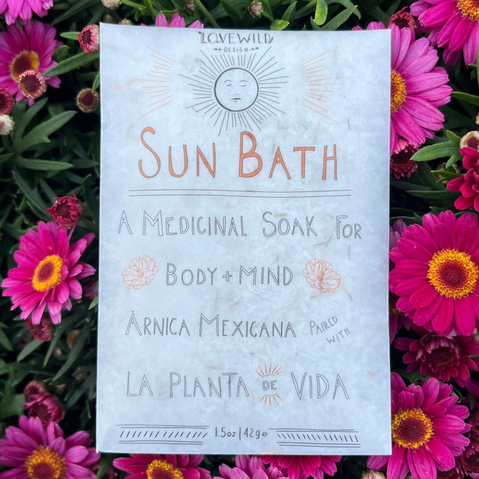 Packaging for 'Sun Bath' a medicinal soak product by Lovewild, with graphical elements such as a sun and flowers, indicating it is a bath additive with natural ingredients.